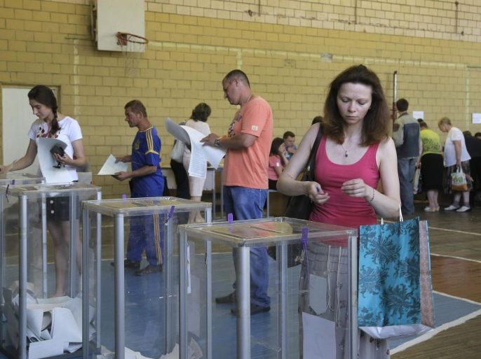 Ukrainians cast their ballots at a polling station during presidential and mayoral elections in Kiev, Ukraine, Sunday, May 25, 2014. Ukraine's critical presidential election got underway Sunday under the wary scrutiny of a world eager for stability in a country rocked by a deadly uprising in the east. (AP Photo/Efrem Lukatsky)