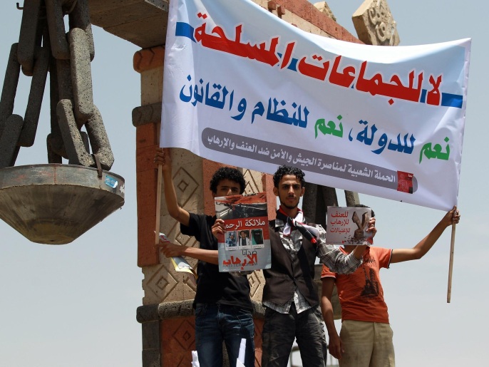 شباب يمنيون يحملون لافتة مؤيدة للجيش في مواجهته 