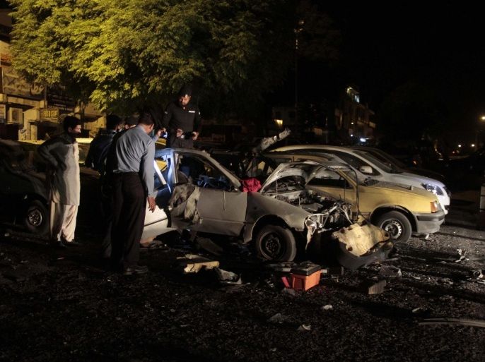 Policemen inspect the scene of a bomb blast in Islamabad, Pakistan, 24 May 2014. At least one person was killed when two bombs exploded one after another at two locations in the capital Islamabad on early 24 May.