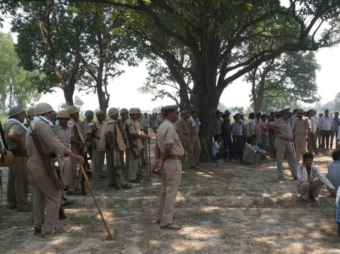 A picture made available on 30 May 2014 showing villagers and policemen gathered where two teenage cousins were found hanging from a mango tree in Katra village in Uttar Pradesh, India, 28 May 2014. Two teenage girls were gang-raped and hanged from a tree in a village in northern India. The girls, cousins aged 14 and 16, went missing in the Badaun district of northern Uttar Pradesh state late 27 May and their bodies were found hanging from a tree the following day. Three men including a policeman were arrested in connection with the incident. Another policeman and three more accused were still said to be at large. EPA/STR BEST QUALITY AVAILABLE.