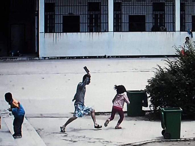 This picture taken on May 20, 2014 from a security video shows a knife-wielding attacker going on a rampage at a Chinese primary school in Macheng, central China's province of Hubei, wounding eight schoolchildren with one seriously hurt. China has seen several violent attacks against children in recent years, including a spate of five incidents in 2010 which killed 17 people -- 15 of them children -- and wounded more than 80. CHINA OUT AFP PHOTO