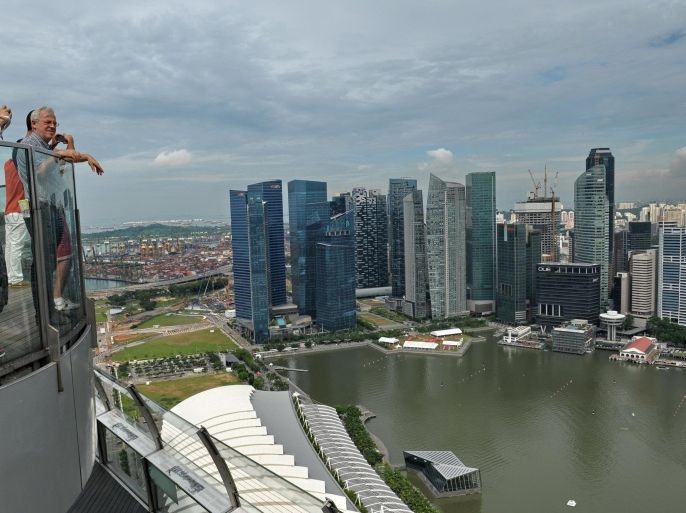 Visitors look at the city skyline from the rooftop garden of Marina Bay Sands resort hotel in Singapore on May 20, 2014. Singapore's trade-reliant economy expanded a seasonally adjusted 2.3 percent quarter-on-quarter the trade ministry said May 20. AFP PHOTO/ROSLAN RAHMAN
