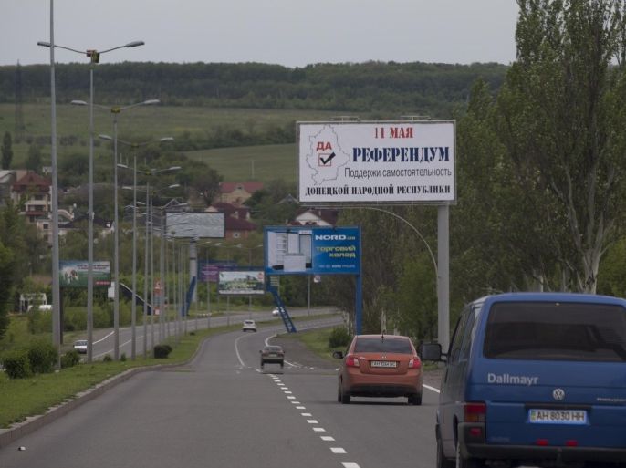 A huge poster reading "May 11 referendum support independence of the People's Republic of Donetsk" overhangs a highway outside Donetsk, Ukraine, Friday, May 9, 2014. People in two regions of restive eastern Ukraine, Donetsk and Luhansk, will vote on Sunday on declaring sovereignty. Issues of legitimacy aside, the vote is sure to add to tensions in an area already gripped by rebellion and sporadic clashes between militants and Ukrainian forces. (AP Photo/Alexander Zemlianichenko)