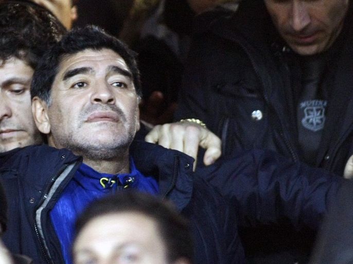Argentine former football player Diego Armando Maradona (L) looks on as he arrives on the stands during the Italian Cup semi-final second leg football match SSC Napoli vs AS Roma at the San Paolo Stadium in Naples, on February 12, 2014. AFP PHOTO/CARLO HERMANN