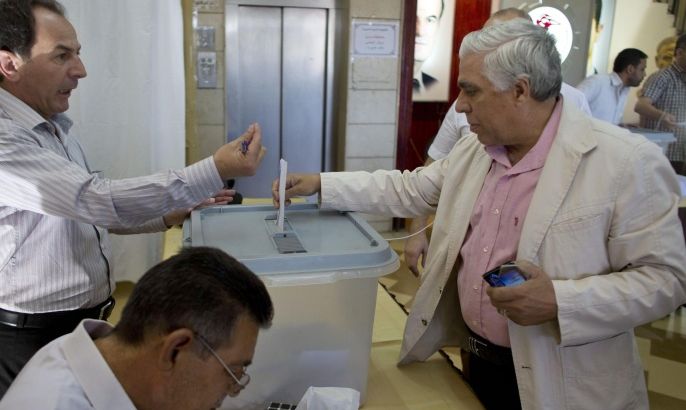 A man votes during the presidential election in Damascus, Syria, Tuesday June 3, 2014. Polls opened in government-held areas in Syria amid very tight security Tuesday for the country's presidential election, a vote that President Bashar Assad is widely expected to win. (AP Photo/Dusan Vranic)