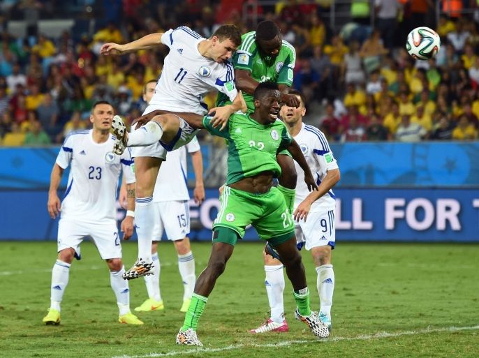 CUIABA, BRAZIL - JUNE 21: Edin Dzeko of Bosnia and Herzegovina directs a header on goal against Kenneth Omeruo of Nigeria during the 2014 FIFA World Cup Group F match between Nigeria and Bosnia-Herzegovina at Arena Pantanal on June 21, 2014 in Cuiaba, Brazil.