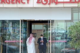 A man, wearing a mouth and nose mask, checks his phone as he leaves the hospital's emergency department on April 27, 2014 in the Saudi capital Riyadh. The MERS death toll in Saudi Arabia neared 100 this weekend as the authorities scrambled to reassure an increasingly edgy population in the country worst-hit by the infectious coronavirus. AFP PHOTO/FAYEZ NURELDINE