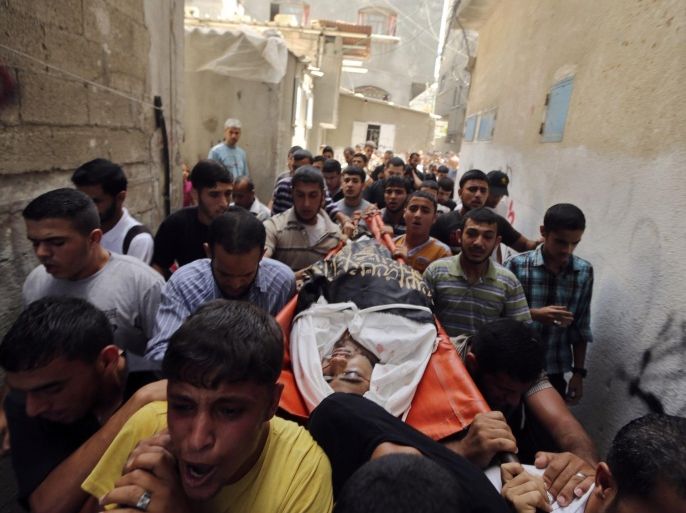 ATTENTION EDITORS - VISUAL COVERAGE OF SCENES OF INJURY OR DEATH Mourners carry the body of Palestinian Islamic Jihad militant Mohammed Sweilem, whom medics said was killed at an Israeli air strike, during his funeral in Jabalya refugee camp in the northern Gaza Strip July 12, 2014. Israel pounded Palestinian militants in the Gaza Strip on Saturday for a fifth day, killing nine people including two disabled women according to medics, and showed no sign of pausing despite international pressure to negotiate a ceasefire. REUTERS/Mohammed Salem (GAZA - Tags: POLITICS CIVIL UNREST TPX IMAGES OF THE DAY) TEMPLATE OUT