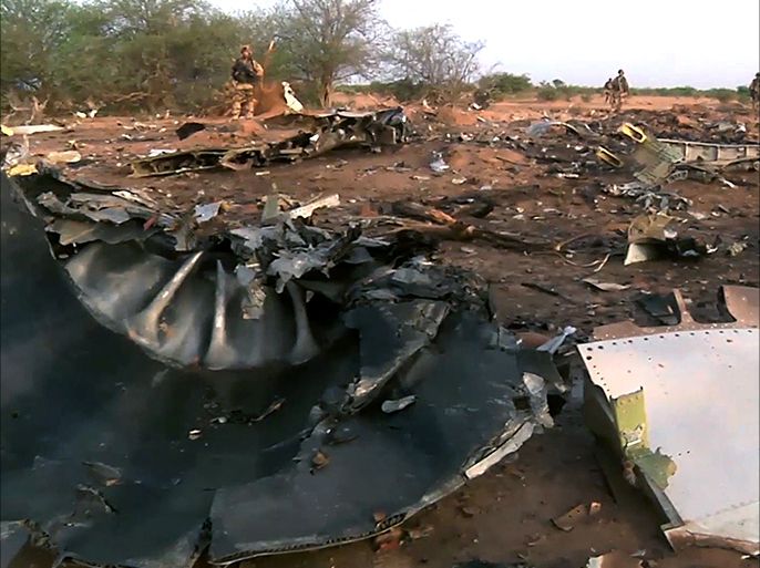 This image grab made from a handout video filmed and released by the French Etat-Major des Armees (EMA) / Armee de Terre on July 25, 2014 shows French soldiers walking near debris at the crash site of the Air Algerie flight AH5017 in Mali's Gossi region, west of Gao