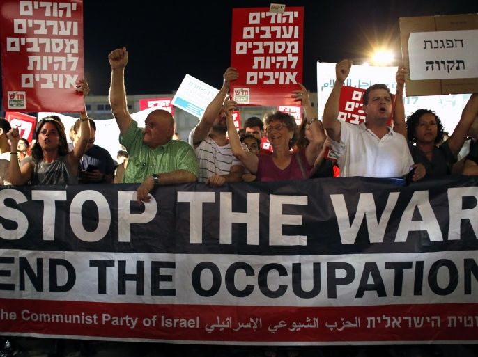 Supporters of peace hold a banner of the communist party reading 'stop the war' as thousands of them gather at the Rabin Square in Tel Aviv on July 26, 2014, to ask for the end of the Israeli military offensive in the Gaza Strip. The conflict has claimed more than 1,000 Palestinian lives, most of them civilians, and has killed 40 Israeli soldiers and three civilians inside Israel. AFP PHOTO / THOMAS COEX