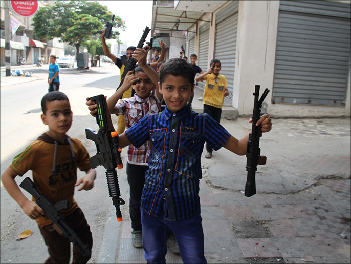 أطفال يلهون بأسلحتهم البلاستيكية (الجزيرة نت)