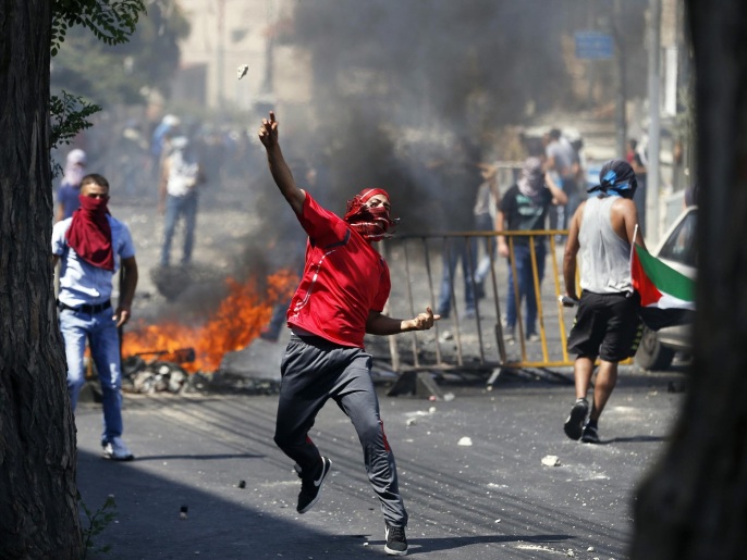 فلسطيني يلقي الحجارة على الشرطة الإسرائيلية أثناء مواجهات شهدها حي وادي الجوز(غيتي إيميجز)
