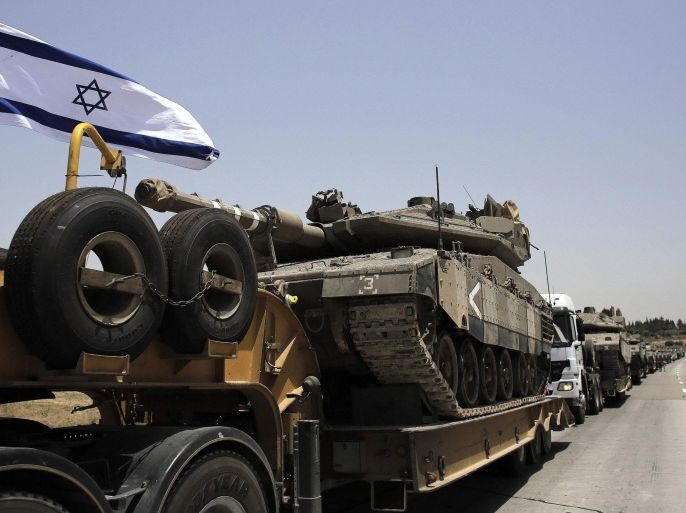 A convoy of Israeli lorries carrying army tanks can be seen on a road leading to southern Israel, at Latrun, near Jerusalem. July 12, 2014. Israel pounded Palestinian militants in the Gaza Strip on Saturday for a fifth day, killing nine people including two disabled women according to medics, and showed no sign of pausing despite international pressure to negotiate a ceasefire. In Israel, a Palestinian rocket seriously wounded one person and injured another seven when it hit a fuel tanker at a service station in Ashdod, 30 km (20 miles) north of Gaza. Islamist militants in Gaza warned they would launch rockets at Tel Aviv's main international airport and warned airlines to stay clear. REUTERS/Ammar Awad (ISRAEL - Tags: POLITICS CIVIL UNREST MILITARY CONFLICT)