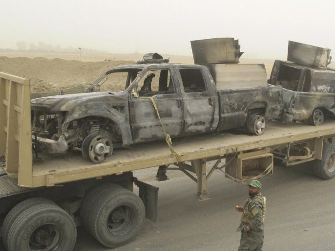 An Iraqi military truck transports burnt vehicles belonging to Iraqi security forces on a road at Salahuddin province July 13, 2014. The vehicles were set on fire during clashes with militants of the Islamic State, formerly known as the Islamic State in Iraq and the Levant (ISIL). Picture taken July 13, 2014. REUTERS/Stringer (IRAQ - Tags: CIVIL UNREST POLITICS MILITARY TRANSPORT)