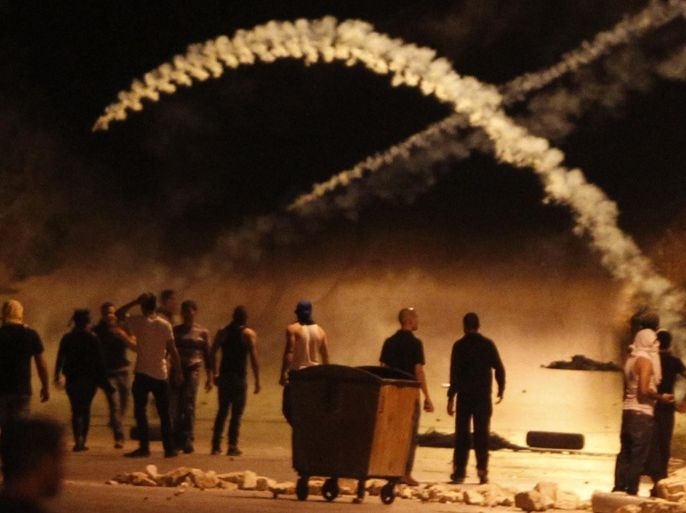 Palestinians clash with Israeli soldiers at the gates of the Beit El Jewish settlement in the Israel occupied West Bank near Ramallah on July 9, 2014, as they protest against the bombardment of the Gaza Strip by the Israeli air force. The Israeli air force bombed 160 targets in the Gaza Strip overnight as it pressed a wide scale campaign to stop volleys of Palestinian rocket fire, an army official said. AFP PHOTO / ABBAS MOMANI