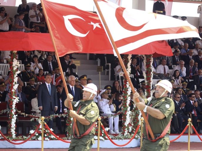 Turkish Cypriot war veterans march with Turkish and Turkish Cypriot flags, past Turkish President Abdullah Gul (back L) and Turkish Cypriot leader Dervis Eroglu, during a military parade celebrating 40 years since Turkey invaded Cyprus, in Nicosia July 20, 2014. Turkish forces landed on the island four decades ago in response to a brief Greek Cypriot coup, partitioning the island since. REUTERS/Andreas Manolis (CYPRUS - Tags: ANNIVERSARY MILITARY POLITICS)