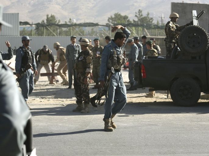 Afghan and foreign security forces inspect the site of a suicide attack at the deputy counter narcotic compound in Kabul, Afghanistan, Tuesday, July 22, 2014. An Afghan official said that four security guards were killed and six others wounded after a suicide bomber on a motorbike carried out the attack (AP Photo/Rahmat Gul)