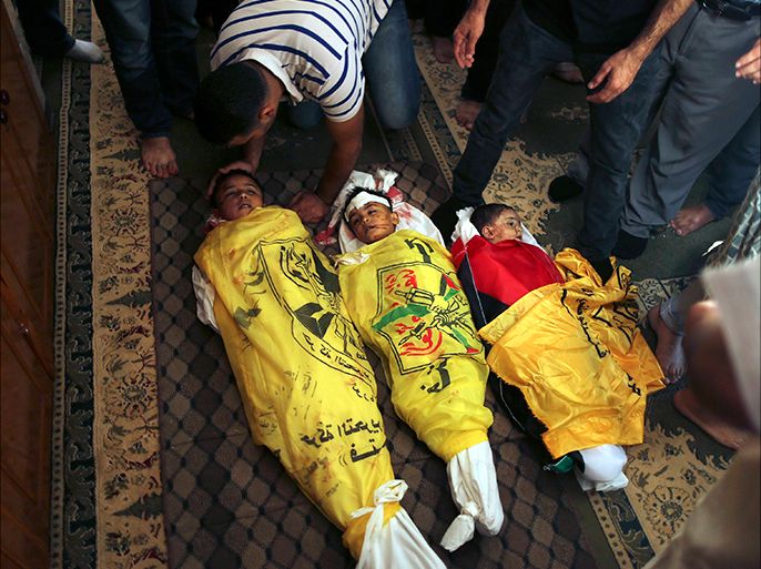 People gather around the bodies of three Palestinian boys, including two brothers from Elwan family (L and C), who medics said were killed in an Israeli tank shell, during their funeral in Gaza City July 19, 2014. Israeli forces on Saturday pressed ahead with a ground offensive in the Gaza Strip, where Palestinian militants kept firing rockets deep into Israel's heartland, pushing the death toll past 300 in almost two weeks of conflict. REUTERS/Mohammed Salem (GAZA - Tags: POLITICS CIVIL UNREST) TEMPLATE OUT