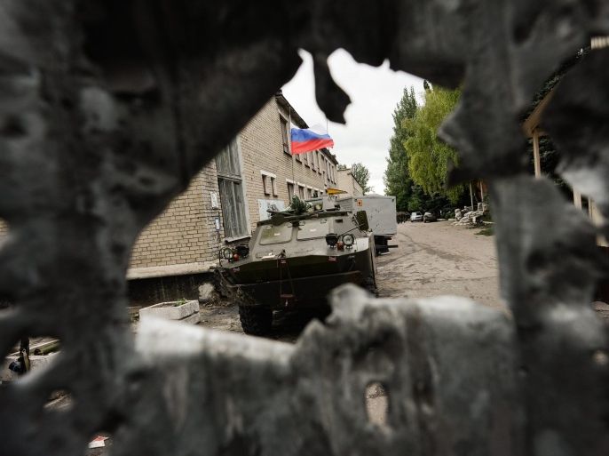 A photograph made available on 28 June 2014 showing an armored personnel carrier, flying a Russian flag, though a hole in the perimiter fence of a Ukrainian national Guard (former Interior troops) base, seized by pro-Russian rebels, in Donetsk, Ukraine 27 June 2014. Reports on 28 June 2014 state that President Petro Poroshenko has prolonged cease fire for 72 hours. EPA/STRINGER PICTURE MADE AVAILABLE TODAY