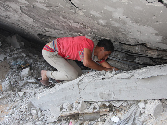 فلسطيني يحفر بين أنقاض المنزلبحثا عن جثث أفراد العائلة(الجزيرة)