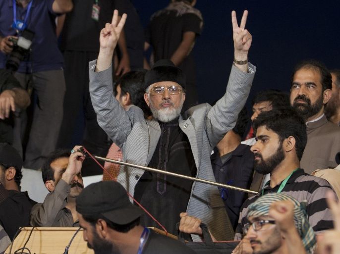 Pakistan's Muslim cleric Tahir-ul-Qadri shows victory signs during a sit-in protest near the parliament building in Islamabad, Pakistan, Wednesday, Aug. 27, 2014. Thousands of Pakistani former cricketer-turned-politician Imran Khan's and Qadri's supporters are besieging parliament in the capital to pressure Prime Minister Nawaz Sharif to resign over alleged election fraud. (AP Photo/B.K. Bangash)