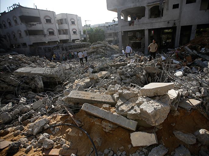 epa04360576 Palestinians inspect the ruble of a destroyed house of the Al-Dalow family after Israeli warplanes targeted their house on 19 August, in Al-Sheikh redwan area in the north of Gaza City, Gaza Strip, 20 August 2014. At least ten Palestinians were killed in the Gaza Strip after three rockets were fired from the Gaza Strip to Israel on 19 August, prompting retaliatory Israeli airstrikes hours before a temporary ceasefire was set to expire. No Palestinian group claimed responsibility for the rocket fire, and no injuries were reported in Israel. Israeli Prime Minister Benjamin Netanyahu ordered his negotiators at talks in Cairo that are aimed at reaching a long-term truce to return home, Israeli media reported after the exchange, citing top officials. EPA/MOHAMMED SABER
