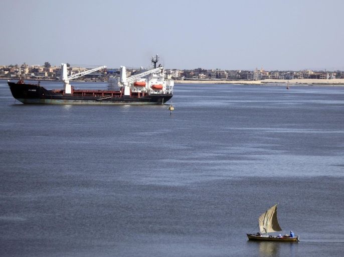 A fisherman travels on a boat near container ships in the Suez Canal, near Ismailia port city, northeast of Cairo in this May 2, 2014 file photo. Egypt is planning to build a new Suez Canal alongside the near-145 year-old historic waterway in a multi-billion dollar project aimed at expanding trade along the fastest shipping route between Europe and Asia. REUTERS/Amr Abdallah Dalsh/Files (EGYPT - Tags: BUSINESS MARITIME)