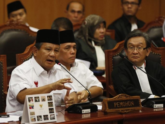 Indonesia's losing presidential candidate Prabowo Subianto (L) addresses the Constitutional Court as his running mate Hatta Rajasa (C) listens in Jakarta August 6, 2014. Prabowo launched a last-gasp attempt to overturn the official election result on Wednesday, telling the nation's highest court last month's vote was tainted by "massive" fraud. REUTERS/Darren Whiteside (INDONESIA - Tags: ELECTIONS POLITICS)