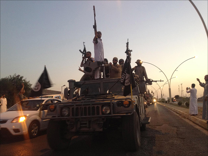 مقاتلون من تنظيم الدولة الإسلامية يجوبون شوارع الموصل (أسوشيتد برس)