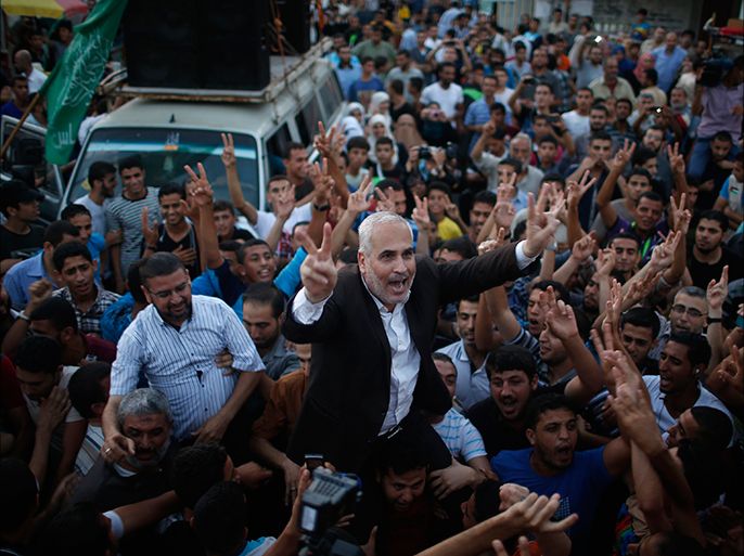 Hamas spokesman Fawzi Barhoum (C) is carried by Palestinians as they celebrate what they said was a victory over Israel following a ceasefire in Gaza City August 26, 2014. Israel has accepted an Egyptian proposal for a Gaza ceasefire, a senior Israeli official said on Tuesday. Egyptian and Palestinian officials said the truce was to take effect at 7 pm (1600 GMT). REUTERS/Mohammed Salem (GAZA - Tags: POLITICS CIVIL UNREST CONFLICT)