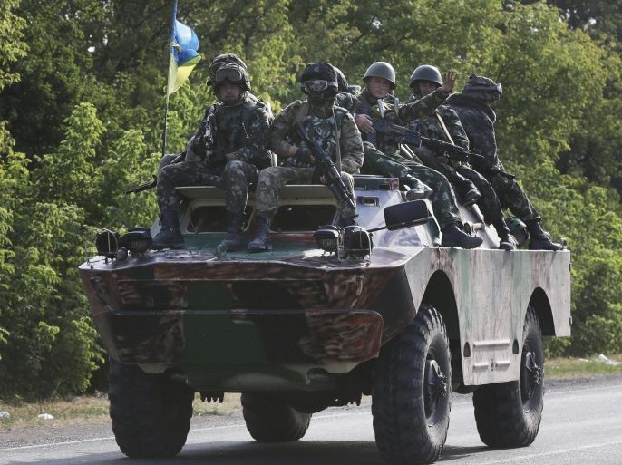 Ukrainian soldiers ride atop an APC near the village of Sakhanka, eastern Ukraine, Wednesday, Aug. 27, 2014. Separatist rebels shelled a town of Novoazovsk in southeastern Ukraine on Wednesday, raising fears they are launching a counter-offensive on government-held parts of the region, one day after the leaders of Ukraine and Russia met to discuss the escalating crisis. (AP Photo/Sergei Grits)
