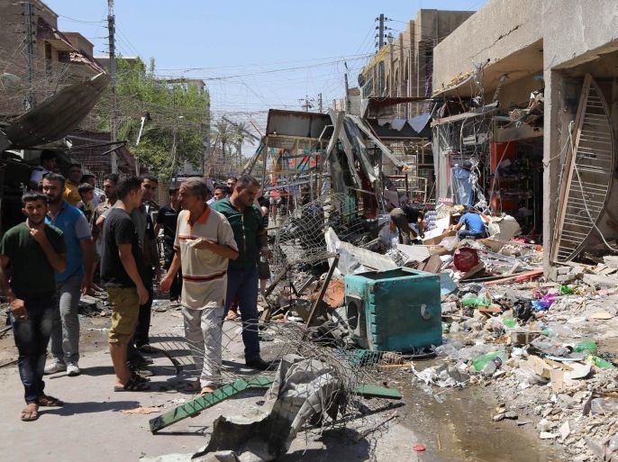 People inspect the site of a car bomb attack in Baghdad, Iraq, Wednesday, Aug. 13, 2014. A string of attacks in and around the capital killed more than a dozen and wounded dozens. (AP Photo/Karim Kadim)