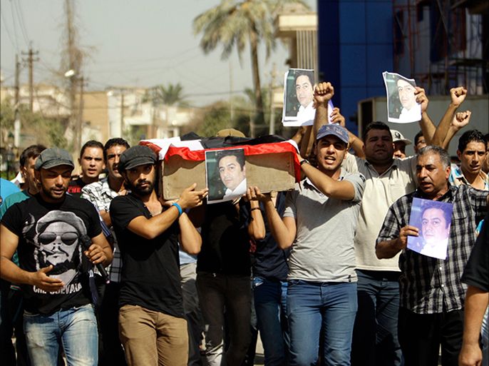 epa02905853 Iraqi demonstrators carry a symbolic coffin of slain journalist Hadi al-Mehdi, who was gunned down with a silenced weapon inside his house, as they take part in a demonstration in central Baghdad, Iraq on 09 September 2011.