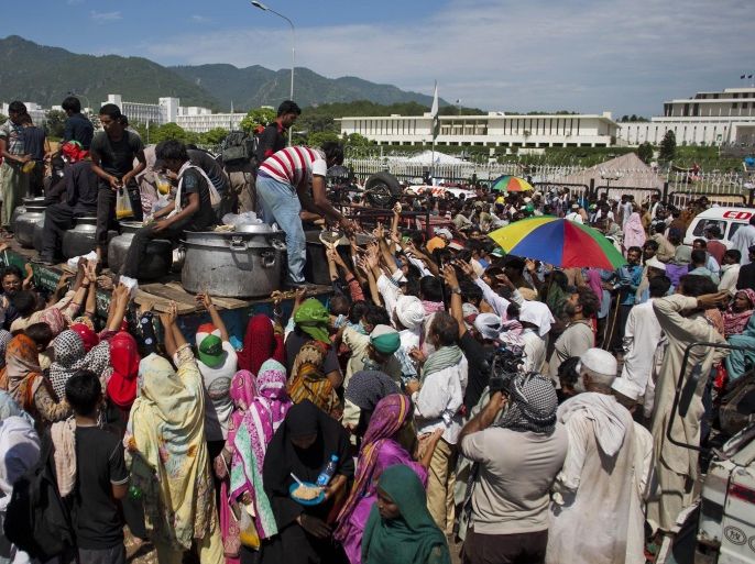 Pakistani protesters receive food, distributed outside parliament in Islamabad, Pakistan, Monday, Sept. 1, 2014. Anti-government protesters and Pakistani police have clashed once again as the demonstrators pushed into a sprawling government complex in the country's capital in an effort to try to reach the prime minister's official residence. (AP Photo/B.K. Bangash)