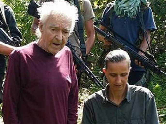 A frame grab from video released by Filipino Islamist group Abu Sayyaf, obtained on 24 September 2014 reportedly shows German hostages identified only as Stefan O (kneeling L) and Henrike D (kneeling R) while being held by the Abu Sayyaf terrorist group in the Philippines. The two have been held captive since April 2014. The group, who's leader has announced support for the Islamic State terror group, has reportedly demanded that Germany stop supporting the US led attacks on the IS and pay a ransom. EPA/ABU SAYYAF VIDEO
