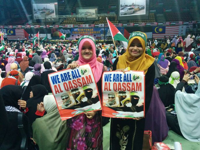 فتيات ماليزيات يحملن شعارات مؤيدة لكتائب عز الدين القسام في احتفال غير مسبوق عقد في ملعب رياضي على بعد أربعين كيلومترا من العاصمة كوالالمبور.