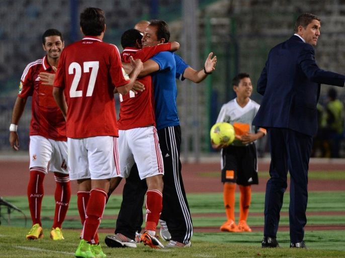 Egypt's Al-Ahly players celebrate with the coaching staff after scoring against Cameroons Coton Sport club during the second leg of their CAF Confederation Cup semi-final football match in Cairo on September 28, 2014. AFP PHOTO / KHALED DESOUKI