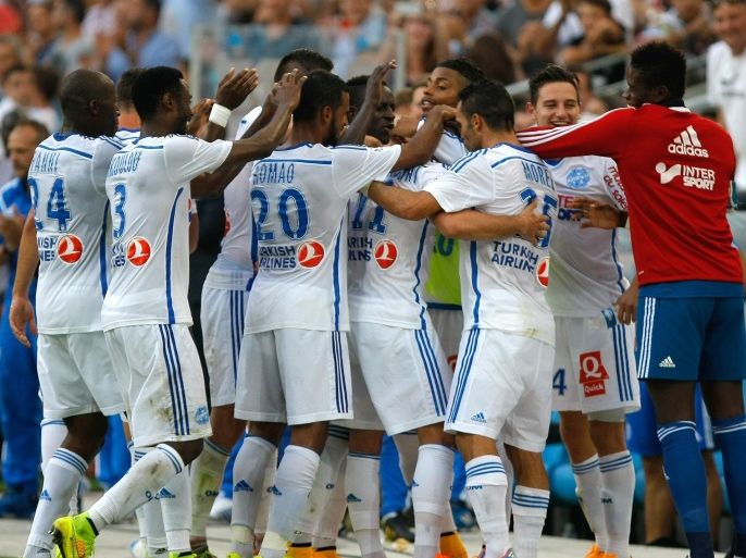 Marseille players celebrate after after Marseille's French midfielder Romain Alessandrini, fourth right, scored against Rennes, during their League One soccer match, at the Velodrome Stadium, in Marseille, southern France, Saturday, Sept. 20, 2014. (AP Photo/Claude Paris)