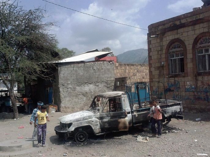 Yemeni boys look at a burnt car outside the local police headquarters that was attacked by suspected al-Qaeda militants as they captured the town of al-Udain in the Ibb Governorate, in southwest Yemen on October 16, 2014. Militants of al-Qaeda's Yemen-based franchise (considered by the United States to be the deadliest branch of the extremist network) stormed the town of Udain overnight, setting fire to the police headquarters and attacking the offices of the local government, a security official and local sources said. AFP PHOTO / STR
