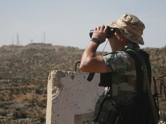 A Lebanese soldier uses a pair of binoculars in the Shebaa area of southern Lebanon, as he looks towards an Israeli position near the border with Israel October 8, 2014. An attack by Hezbollah on Lebanon's border with Israel which wounded two Israeli soldiers was a message that the group remained ready to confront its old foe despite its engagement in Syria's civil war, the group's deputy leader said. The soldiers were wounded by a bomb planted by Lebanese Hezbollah fighters in the Shebaa hills, drawing Israeli artillery fire in response. It was the first time Hezbollah has claimed responsibility for an attack against the Israeli army since 2006, when the two sides fought a 33-day war. REUTERS/Karamallah Daher (LEBANON - Tags: POLITICS CIVIL UNREST MILITARY)