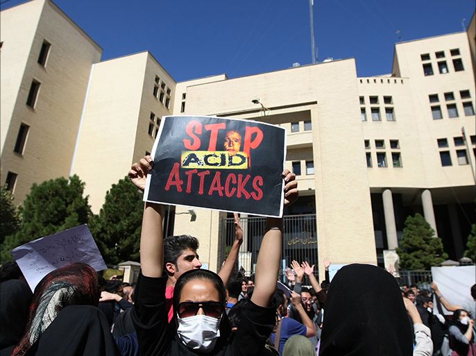 An Iranian woman, hiding her face not to be identified, raises up a placard during a protest in front of the judiciary building on October 22, 2014 in Isfahan, 450 kilometres south of Tehran, in solidarity with women injured in a series of acid attacks. Around 1,000 people took part in the protest calling for better security with banners and placards demanding action after four women have been maimed by assailants on motorcycles who threw acid on them. The acid attacks have prompted speculation on social networks that the victims were targeted because they were "badly veiled," and female drivers have been urged to keep their car windows closed. AFP PHOTO/ISNA/ARYA JAFARI