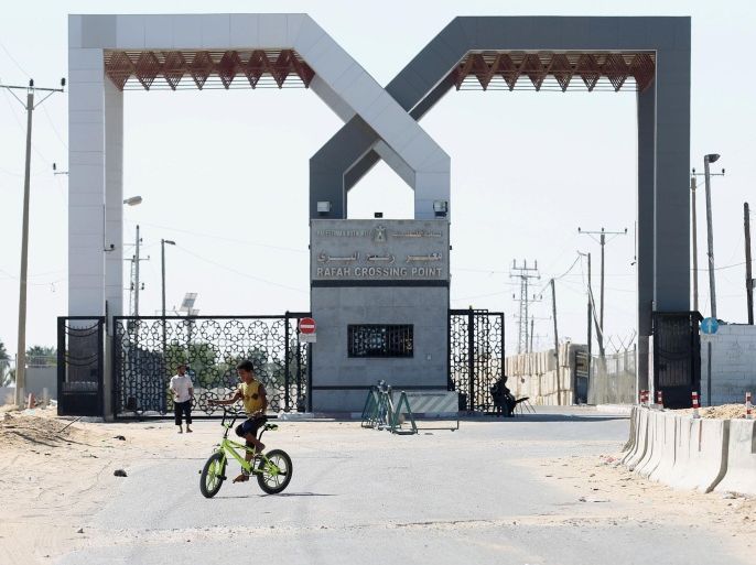 A Palestinian security officer sits near the gate under Palestinian control at the Rafah border crossing with Egypt in the southern Gaza Strip October 25, 2014. The decision was taken to close the Rafah crossing into the Gaza Strip, the only route into the Palestinian territory not controlled by Israel, as Egypt declared a three-month state of emergency in the north and centre of the Sinai Peninsula after a suicide car bombing killed 30 soldiers. AFP PHOTO/ SAID KHATIB