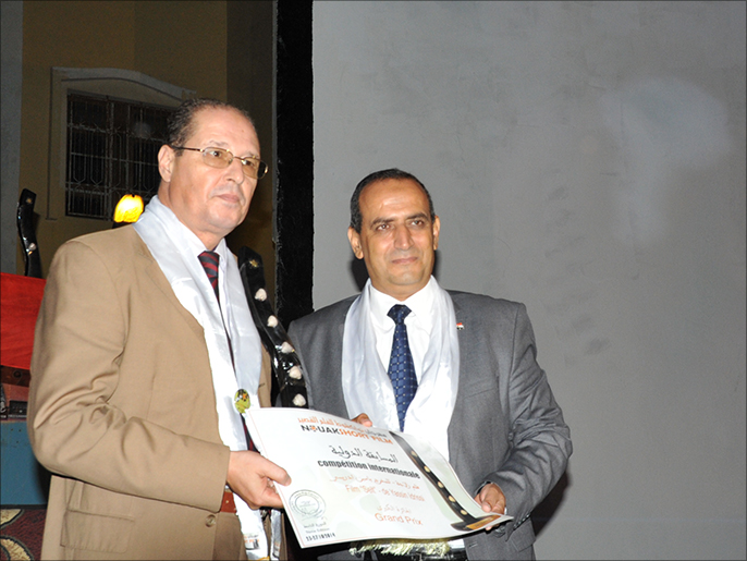 مدير المركز الثقافي المغربي (يسار) تسلم الجائزة باسم مخرج فيلم زلاجة (الجزيرة نت)