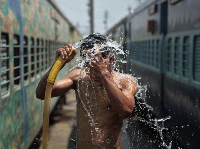 A man takes a shower at a railway station to cool himself down in Jammu, India, Monday, June 9, 2014. A strong heat wave has the northern plains of the country in its grips with temperatures crossing 113 degree Fahrenheit (45 degree Celsius) in several places. (AP Photo/Channi Anand)