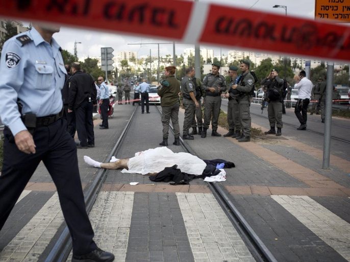Israeli police near the body of a Palestinian man, identified as Ibrahim al-Akari, after he was shot and killed on the Light Rail trolley system in East Jerusalem, 05 November 2014. The man drove a van into a crowd of police and civilians on the rail tracks, killing one person and injuring 14 others. He then drove and had a traffic accident several hundred meters away. When exiting his van yielding a metal bar an Israeli Border Policeman shot and killed him, according to the police. EPA/TALI MAYER ISRAEL OUT