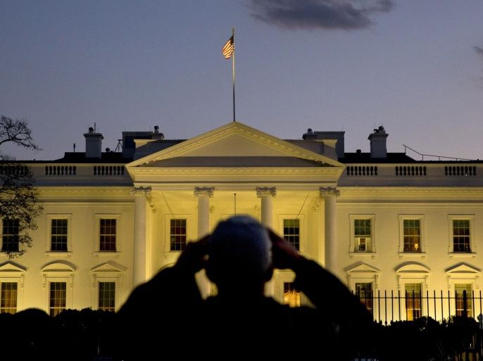 A man takes a cell phone photograph of the White House as dusk falls in Washington, Thursday, Nov. 20, 2014, hours before President Barack Obama is expected to announce steps he will take to shield millions of immigrants illegally in the United States from deportation. (AP Photo/Jacquelyn Martin)