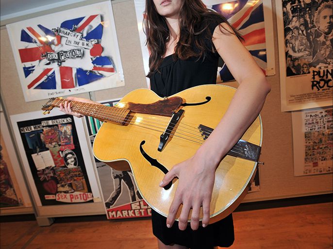 epa01773237 A model holds a 1958 Hofner Senator guitar (estimated 100,000-150,000 GBP) which used to belong to singer John Lennon at Christie's South Kensington in West London during a press view and media photocall to capture exclusive images of the Pop Culture: Rock & Pop sale featuring 200 items of rock and pop memorabilia 25 June 2009. Christie's South Kensington featuring 200 memorabilia items with estimates ranging from 300 to 150,000 GBP the Pop Culture sale is headlined by three guitars from three legends of the British music scene; John Lennon, Brian Jones and Jimi Hendrix. The items go on sale 01 July. EPA