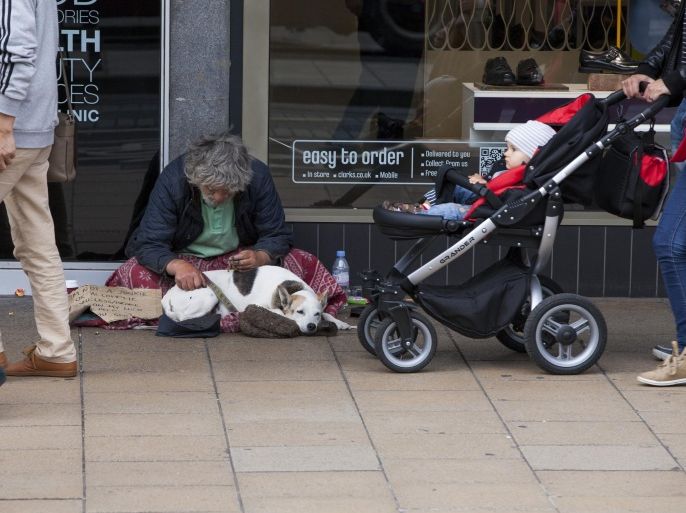 EDINBURGH, SCOTLAND, GREAT BRITAIN - AUGUST 18: A homeless man with a dog panhandles on Princes Street in the heart of the shopping district, on August 18, 2014 in Edinburgh, Scotland, Great Britain.