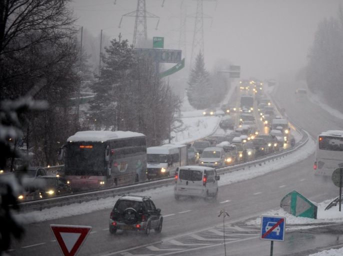 Traffic bound for French Alpine ski resorts moves slowly along the highway in the direction of Moûtiers from Albertville early on December 28, 2014 . Heavy snowfall in the French Alps left some 15,000 drivers stranded overnight, forcing many to pass the night in their cars and prompting officials to open emergency shelters. The snow and ice hit as a rush of holidaymakers were heading to and leaving from ski resorts in the Savoie region in southeastern France, where authorities set up shelters in at least 12 towns. AFP PHOTO / Jean-Pierre Clatot