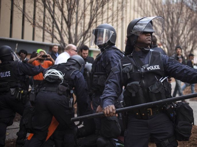 Police in riot gear detain protesters, who were demanding justice for Michael Brown, for disrupting traffic in downtown St. Louis, Missouri November 30, 2014. Officer Darren Wilson announced his resignation late Saturday, saying he feared for his own safety and that of his fellow police officers after a grand jury decided not to indict him in the fatal Aug. 9 shooting of 18-year-old Michael Brown. Anger spilled onto the playing field when the NFL's St. Louis Rams played Oakland at home on Sunday. Some of the Rams entered the stadium with their hands raised overhead, a show of solidarity with Brown, who some witnesses say had his hands in the air when Wilson fired the fatal shots. About 40 or 50 protesters blocked a street outside of Edward Jones Dome during the game. REUTERS/Adrees Latif (UNITED STATES - Tags: CIVIL UNREST CRIME LAW)